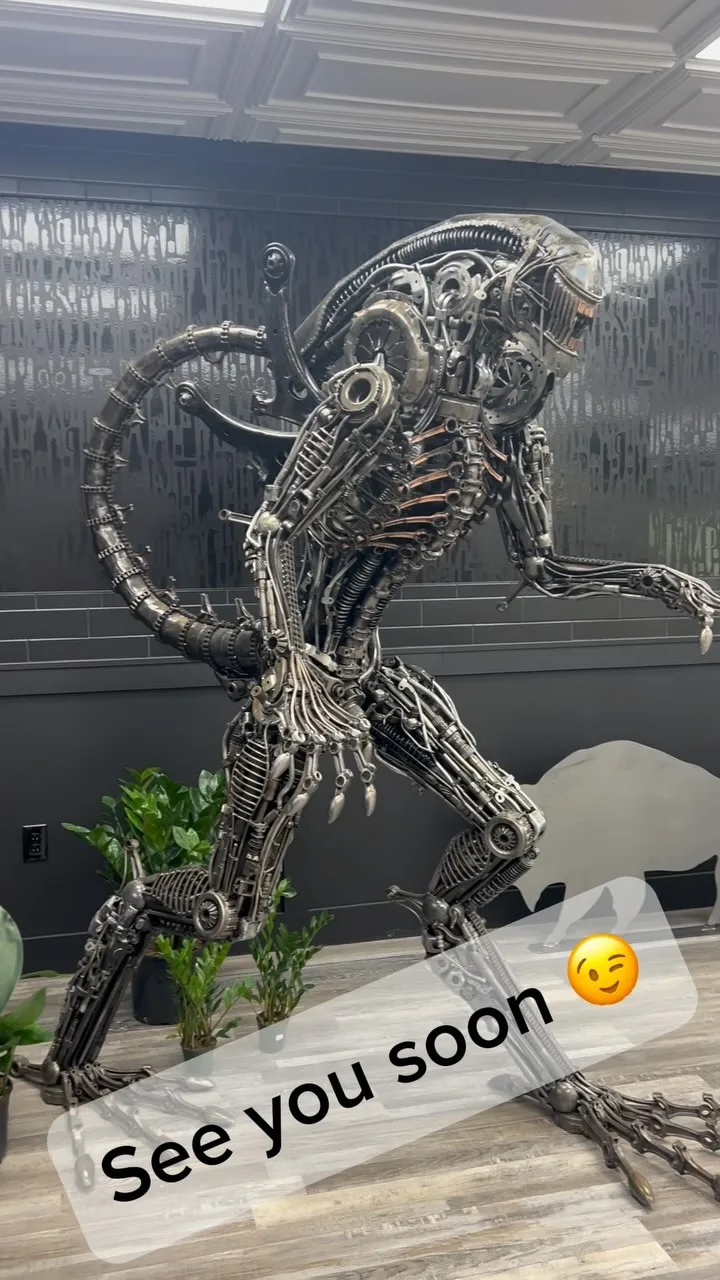 There's a 9-Foot Alien Made of 1,200 Recycled Metal Parts Standing Inside a Plant Shop on Grand Island Boulevard